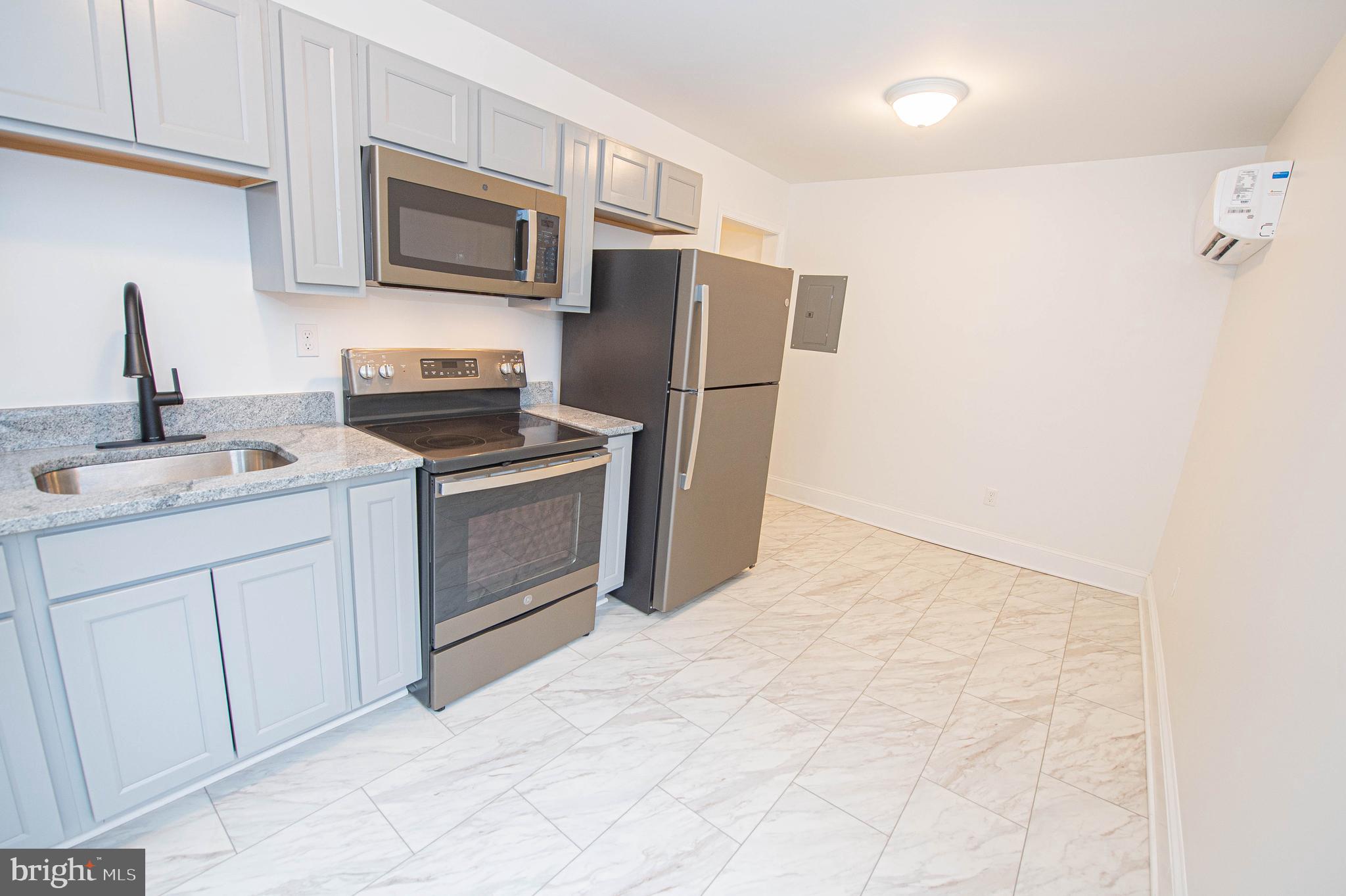 308 North Division Street, Unit 7 Salisbury, MD 21801 - Photo 34 of 56 a kitchen with stainless steel appliances granite countertop a refrigerator stove and sink