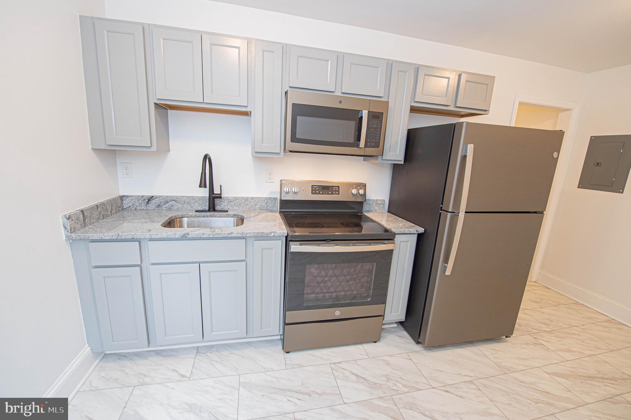 308 North Division Street, Unit 7 Salisbury, MD 21801 - Photo 35 of 56 a kitchen with stainless steel appliances granite countertop a refrigerator sink and stove