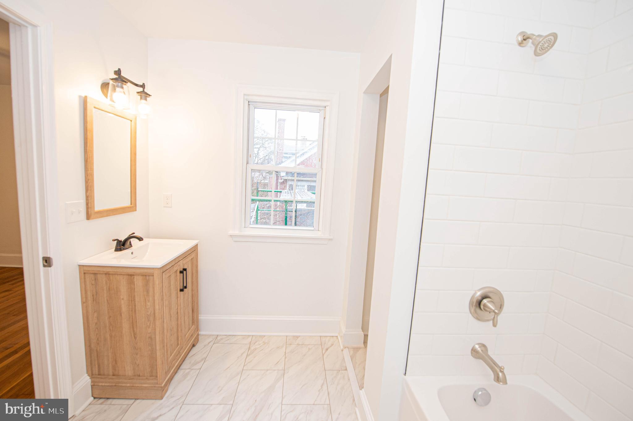 308 North Division Street, Unit 7 Salisbury, MD 21801 - Photo 52 of 56 a bathroom with a sink a tub and a mirror