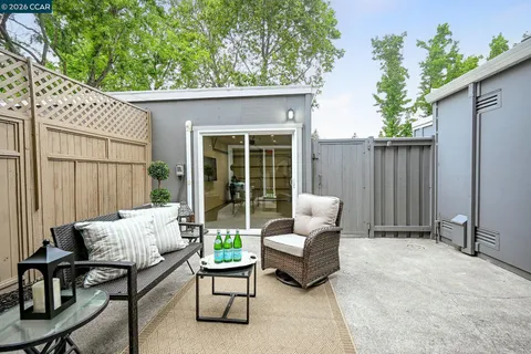 a patio with couches and a potted plant