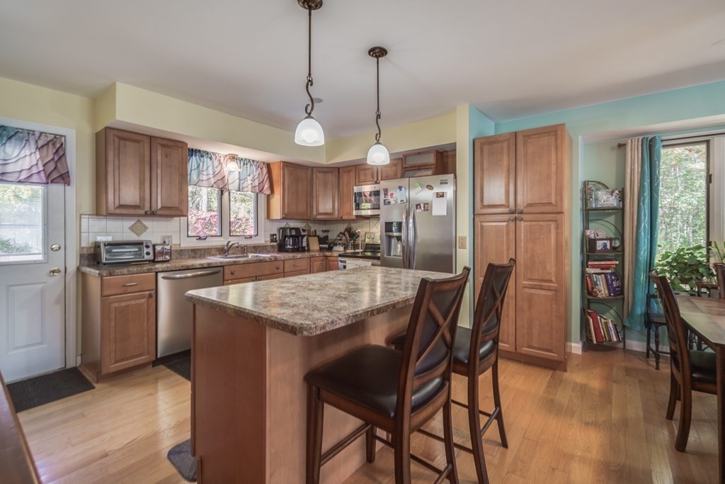 610 County Road, Unit 5 Holyoke, MA 01040 - Photo 6 of 33 a kitchen with stainless steel appliances granite countertop a table chairs refrigerator and microwave