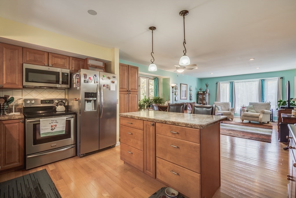 610 County Road, Unit 5 Holyoke, MA 01040 - Photo 8 of 33 a kitchen with stainless steel appliances granite countertop a refrigerator a sink dishwasher a oven with white cabinets and wooden floor