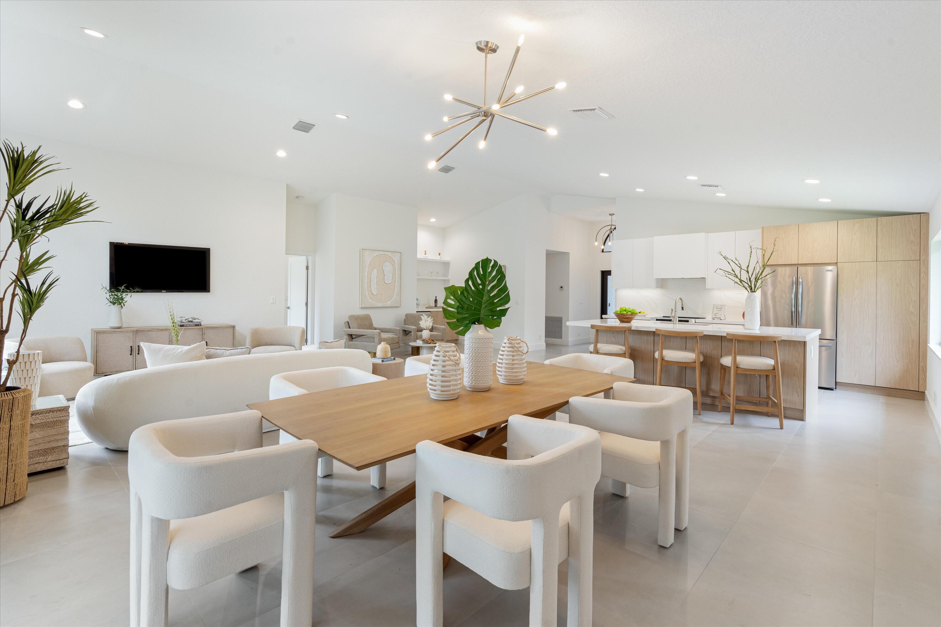 1175 Sea Grape Circle Delray Beach, FL 33445 - Photo 17 of 42 a view of kitchen with kitchen island stainless steel appliances refrigerator stove dining table and chairs