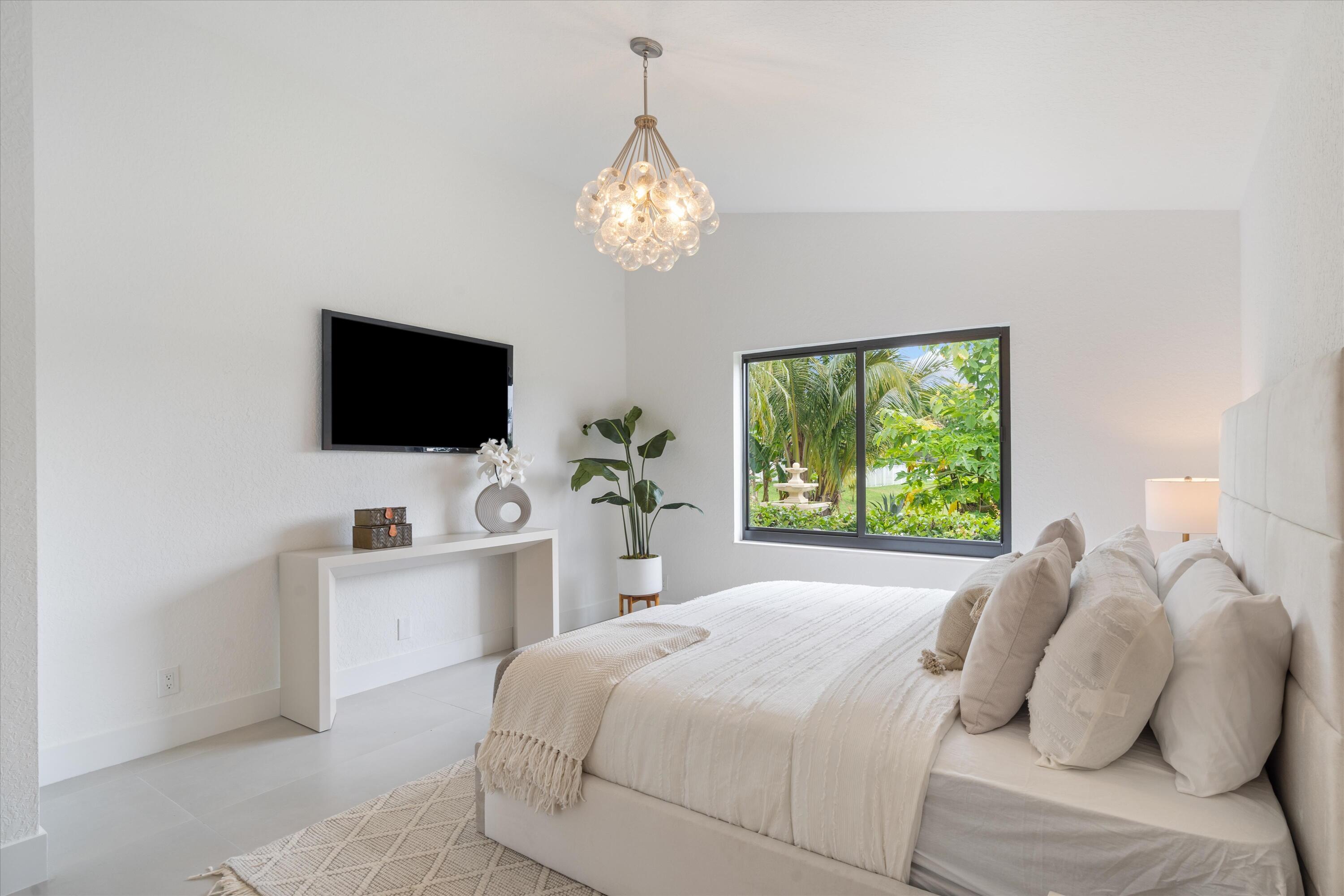 1175 Sea Grape Circle Delray Beach, FL 33445 - Photo 23 of 42 a bedroom with a bed and a flat screen tv