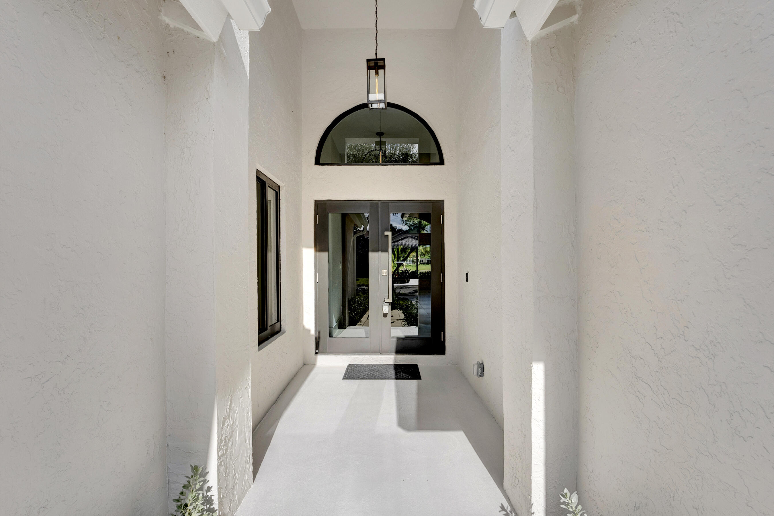 1175 Sea Grape Circle Delray Beach, FL 33445 - Photo 5 of 42 a picture of a hallway with wooden floor and a glass door