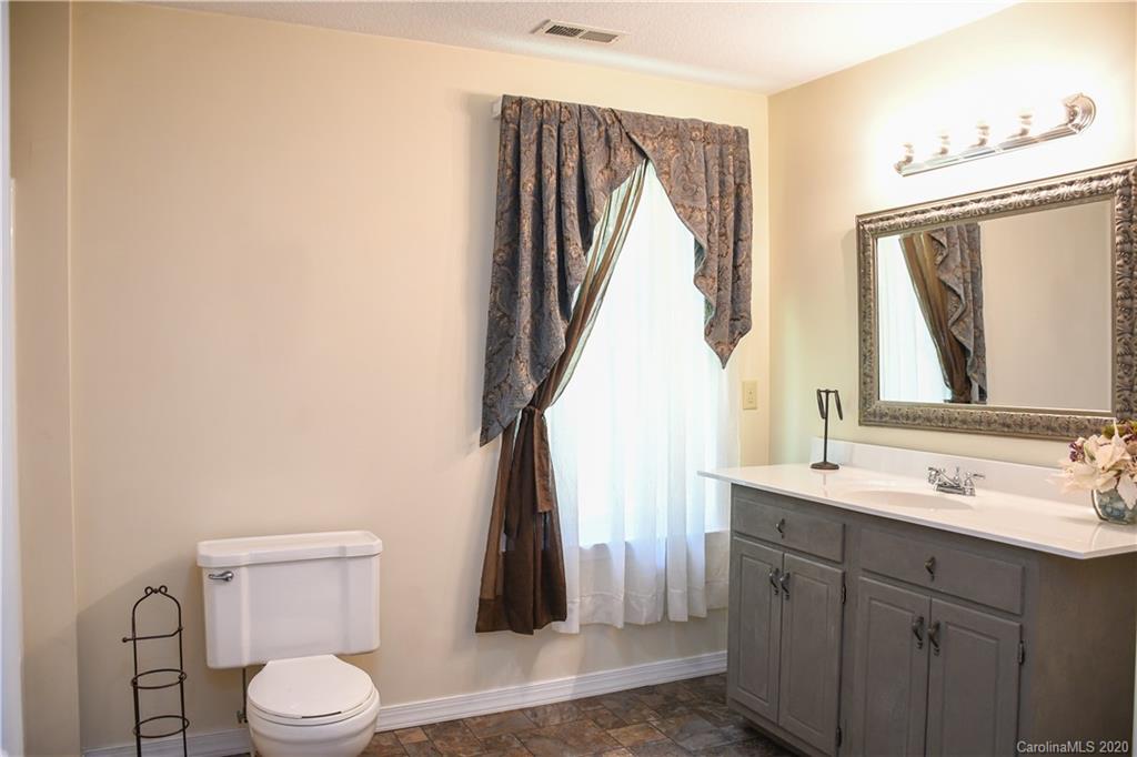 621 Incinerator Road Clyde, NC 28721 - Photo 14 of 27 a bathroom with a toilet a sink and a mirror