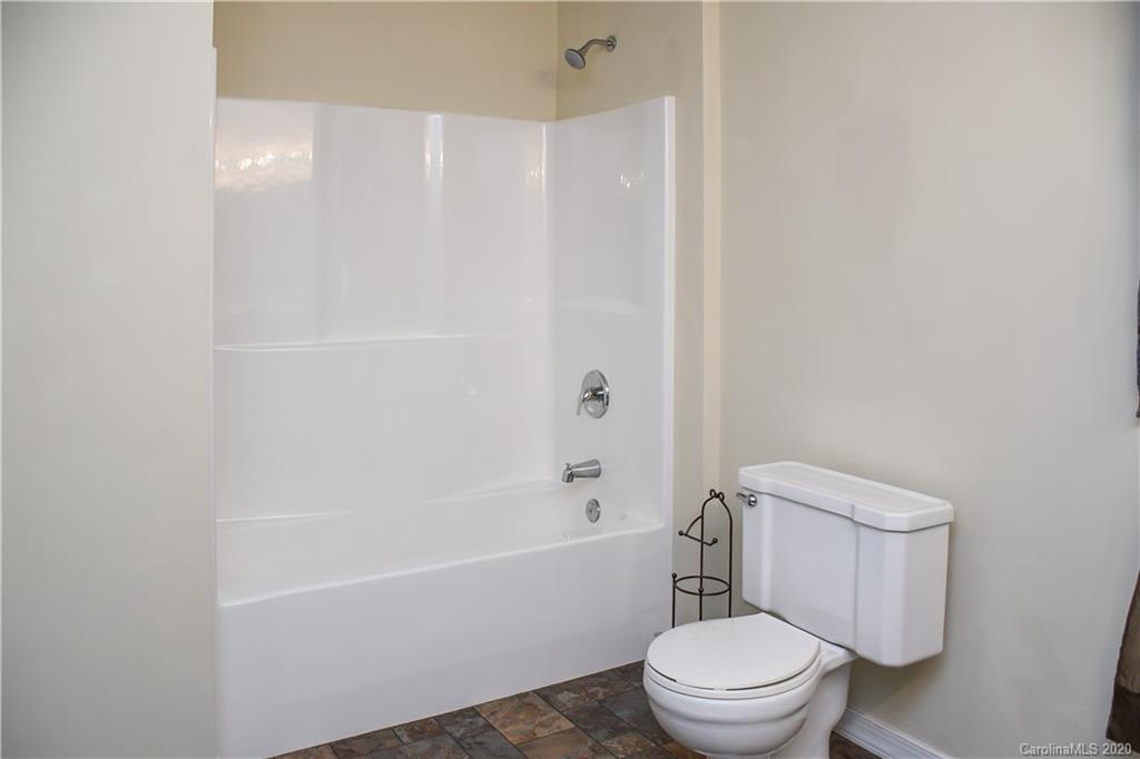 621 Incinerator Road Clyde, NC 28721 - Photo 15 of 27 a white toilet and a shower curtain