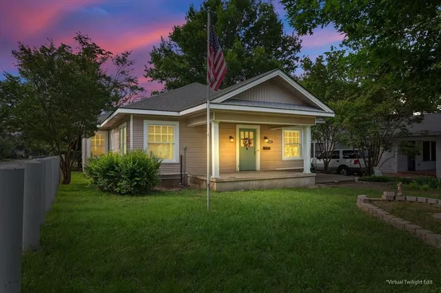 a front view of a house with a yard and trees