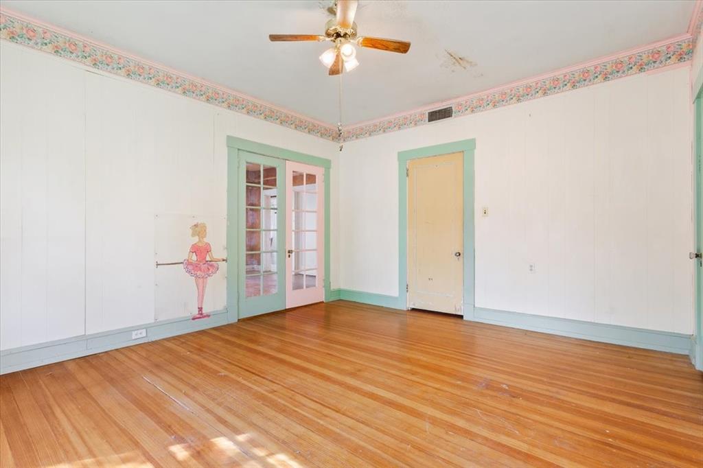 2600 Colcord Avenue Waco, TX 76707 - Photo 21 of 37 a view of an empty room with wooden floor and a ceiling fan