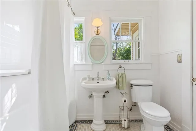a bathroom with a toilet sink and mirror