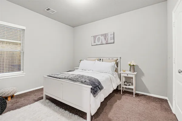 a bed sitting in a bedroom next to a window