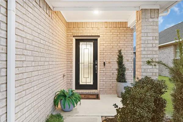 a view of a brick house with potted plants