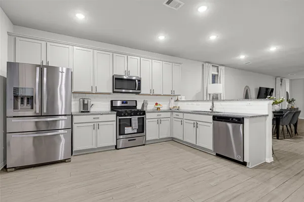 a kitchen with stainless steel appliances a refrigerator sink and microwave