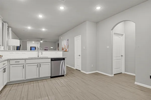 a kitchen with white cabinets and sink