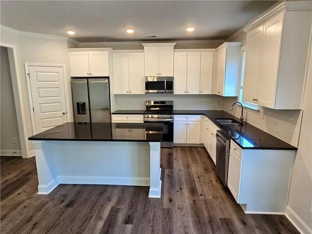 an empty room with wooden floor fireplace and windows
