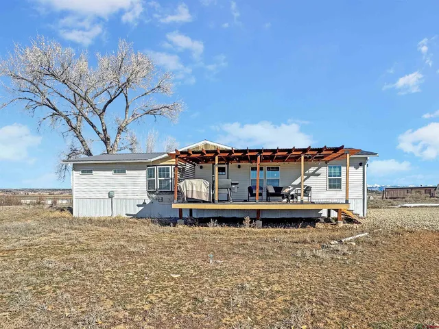 a view of a house with a yard and large tree