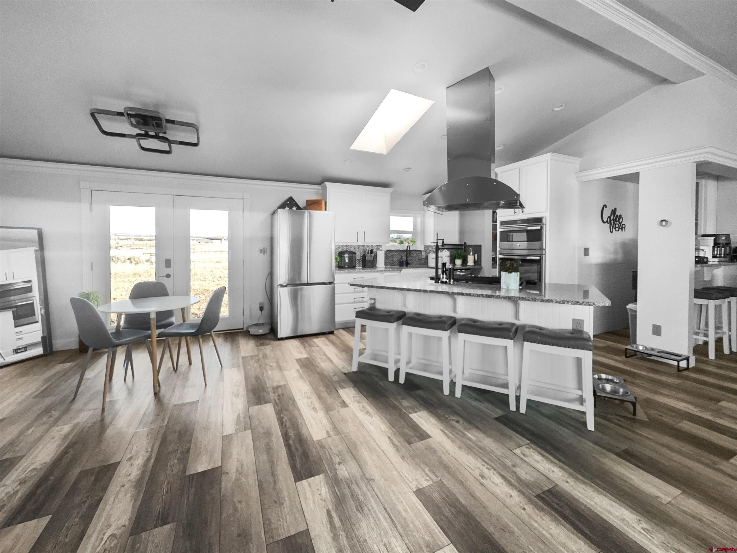 10880 Road 26 Cortez, CO 81321 - Photo 20 of 43 a living room with stainless steel appliances kitchen island granite countertop furniture and a wooden floors