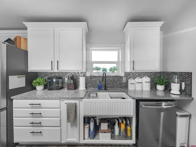 a kitchen with stainless steel appliances kitchen island granite countertop a refrigerator and a counter space