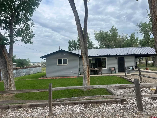 a view of a yard in front of a house with large trees