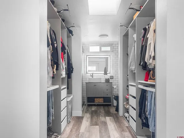 a view of walk in closet with clothes and shoes