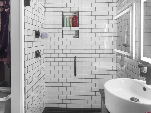 a bathroom with a white sink a toilet and shower