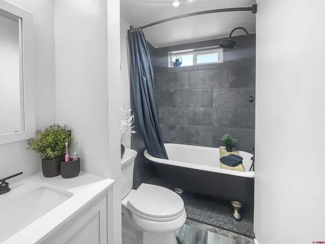 a bathroom with a sink a toilet a tub and shower