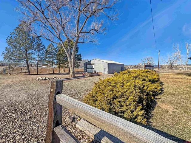 a view of a yard with wooden fence
