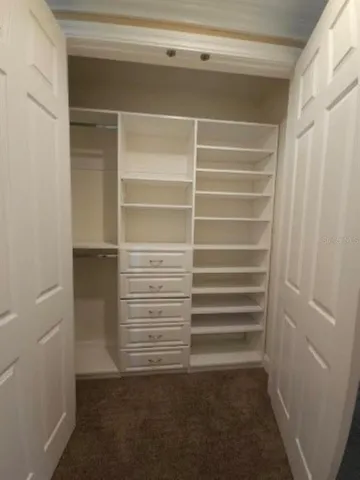 a view of walk in closet with empty racks