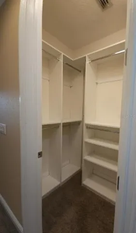 a view of walk in closet with empty racks