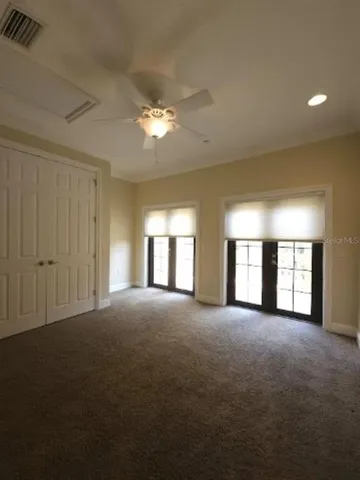 a view of empty room with windows and ceiling fan