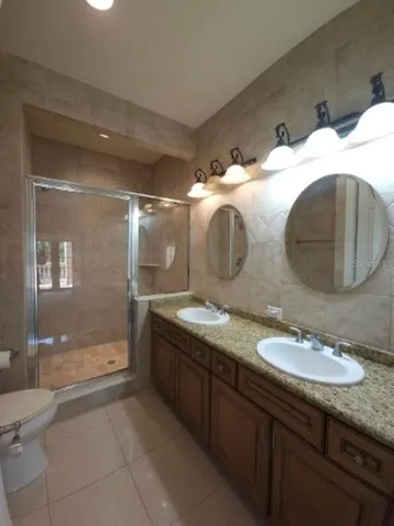 a bathroom with double vanity and a mirror