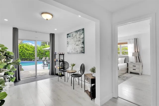 a living room with furniture a potted plant and a large window