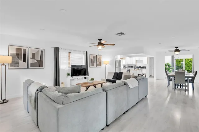a living room with furniture a ceiling fan and a rug