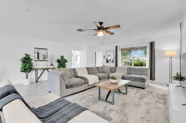 a living room with furniture a flat screen tv and a large window