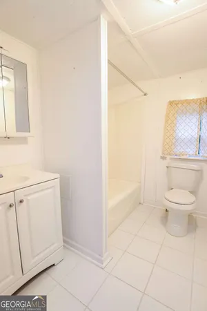 a bathroom with a granite countertop toilet and a sink