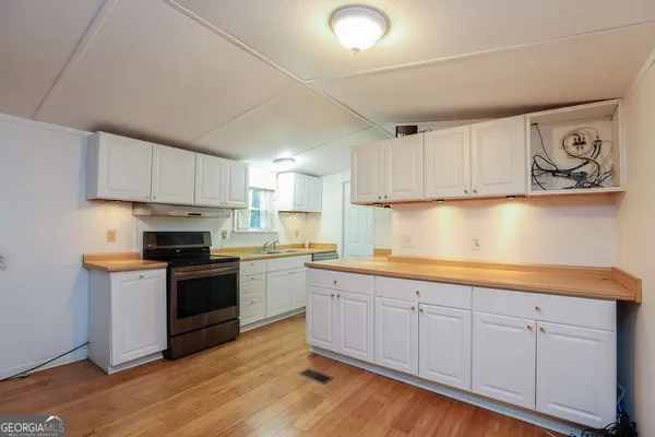 a kitchen with granite countertop white cabinets and stainless steel appliances
