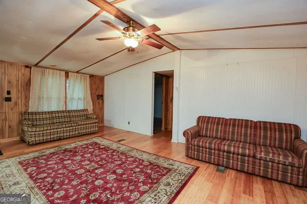 a view of a bedroom with wooden floor and ceiling fan