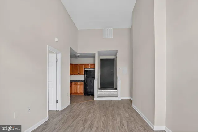 a view of a hallway with wooden floor and closet