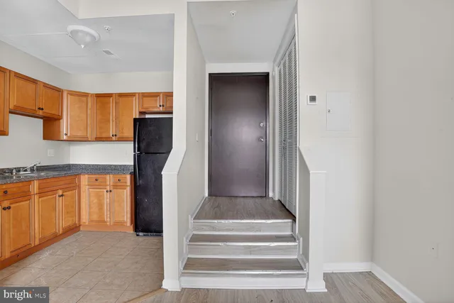 a view of living room kitchen with stainless steel appliances granite countertop cabinets and fireplace