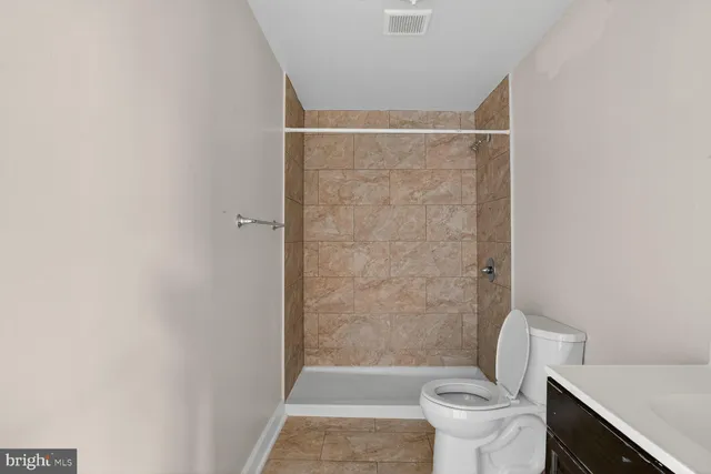 a bathroom with a toilet and a shower