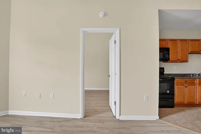 a kitchen with stainless steel appliances granite countertop a stove top oven a sink dishwasher and cabinets with wooden floor