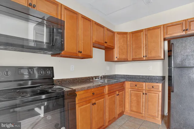 a kitchen with granite countertop wood cabinets and stainless steel appliances