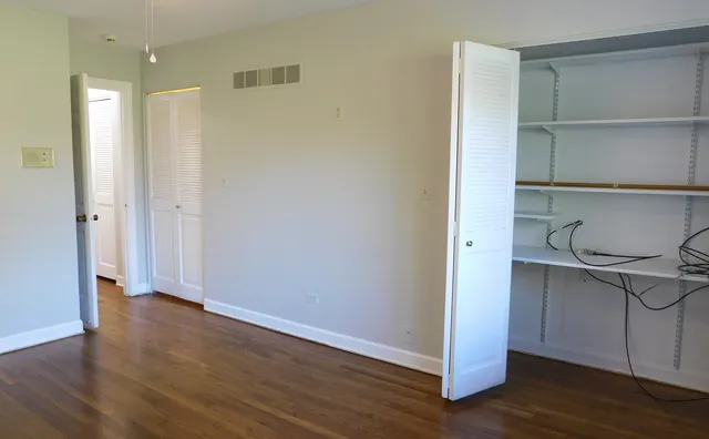a view of a kitchen with wooden floor and cabinets