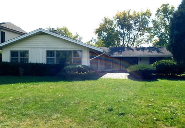 a view of a house with a yard and potted plants
