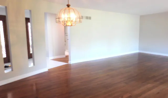 a view of empty room with wooden floor and window