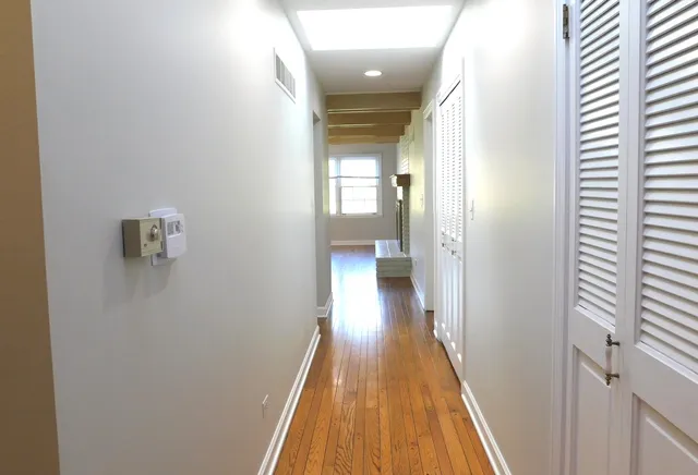 a view of a hallway with wooden floor