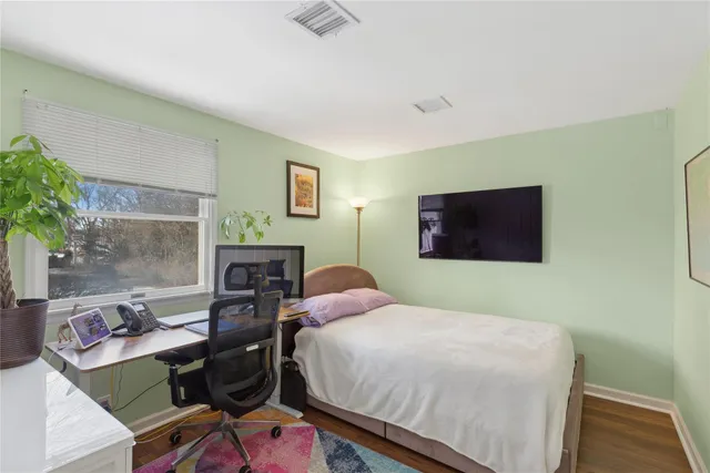 a bedroom with a bed and wooden floor