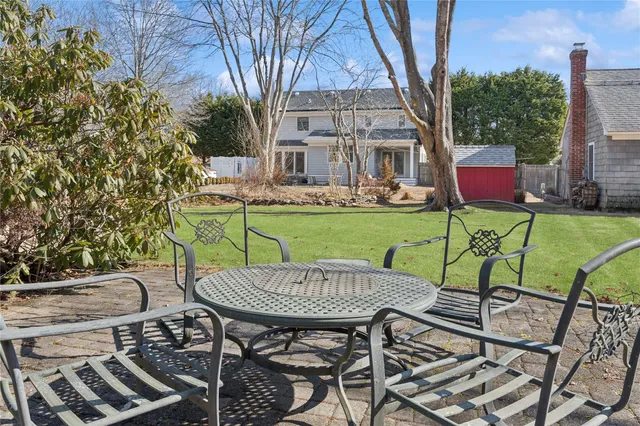 a white house with a yard and a large tree