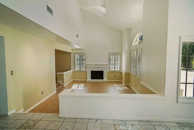 a view of a livingroom with a fireplace and window