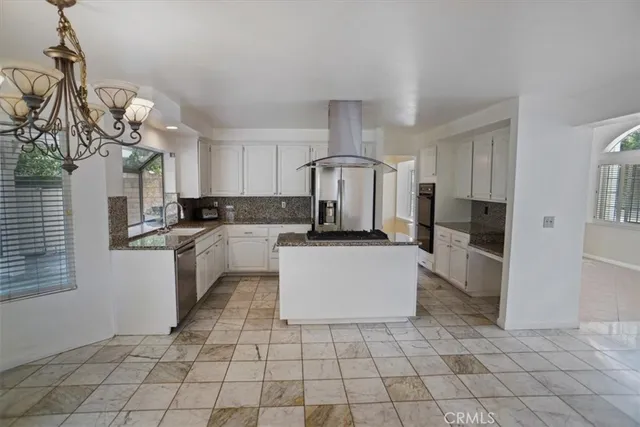 a kitchen with a sink a counter top space cabinets and stainless steel appliances